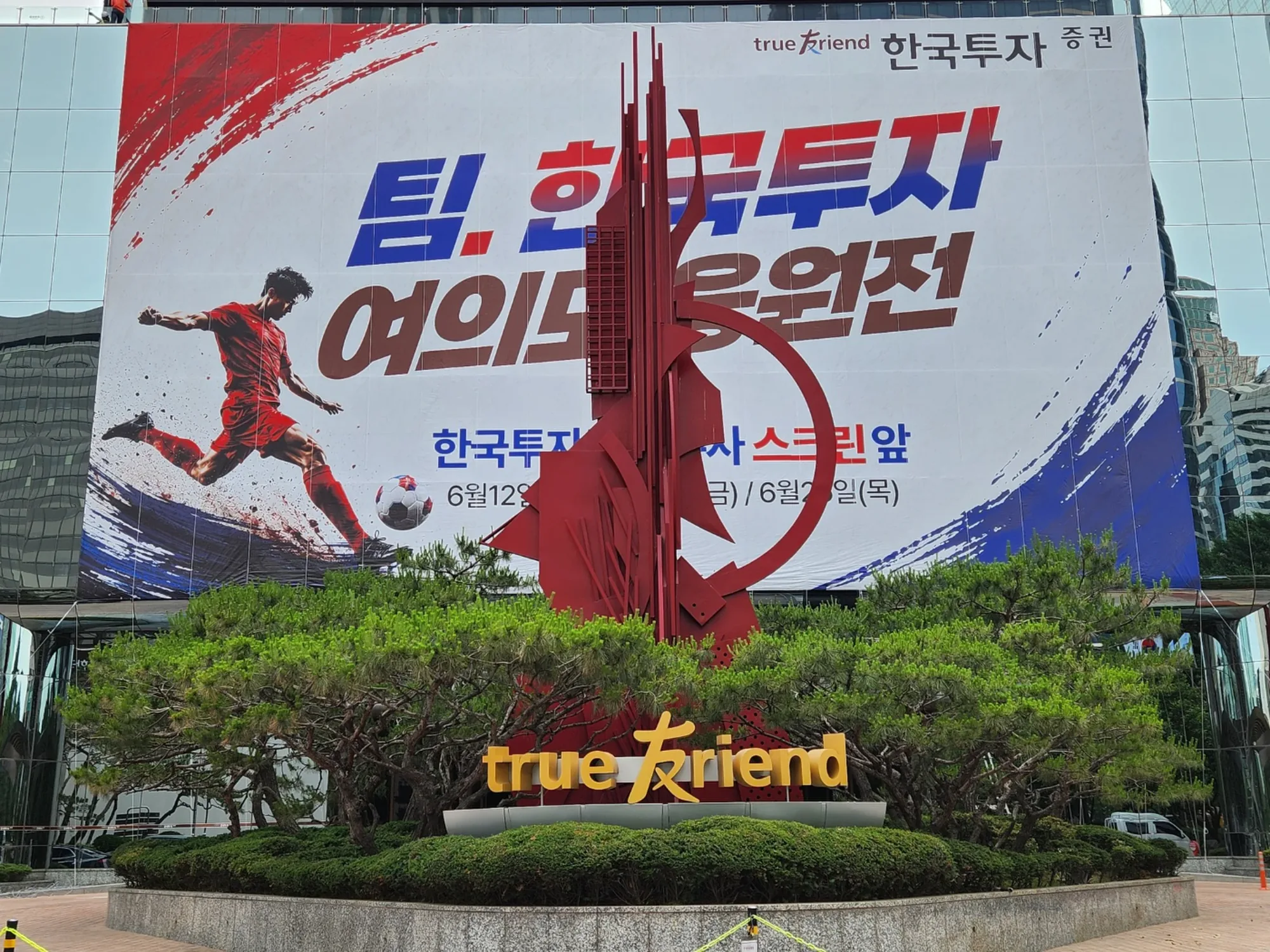 한국투자증권 본사 건물 외벽에 설치된 대형 응원 현수막, 거리에서 올려다본 완공 모습